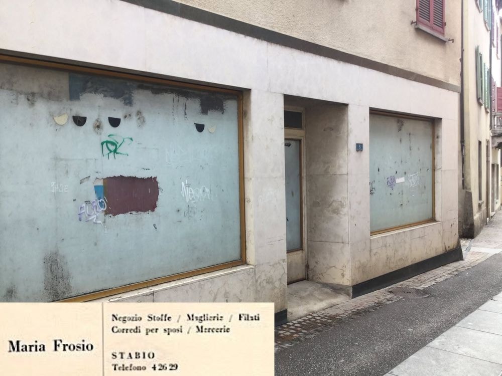 1883-1980, DA LUIGI FONTANA A MARIA ED EMMA FROSIO… Questa bottega affonda le sue radici nell’Ottocento, nata come storica salsamentaria e negozio di vino al minuto. Fondata prima del 1° gennaio 1883, la ditta vedeva al timone il signor Luigi Fontana, originario di Seseglio (frazione di Pedrinate) ma stabilmente domiciliato a Stabio. La sua attività ha rappresentato a lungo un punto di riferimento fondamentale per il commercio di generi alimentari e vitivinicoli della regione. Con il passare degli anni, l'offerta commerciale del comune si è arricchita e diversificata. Il 13 aprile 1928 segna l'iscrizione sulla scena locale della ditta individuale di Maria Frosio, incentrata sul commercio di stoffe, maglieria, merceria e generi diversi. La titolare, Maria Frosio del fu Giovanni, proveniente da Selino (in provincia di Bergamo) e residente a Stabio, ha saputo radicare con successo la propria attività nel cuore della comunità. Quarant'anni più tardi, quella stessa tradizione tessile ha vissuto un importante passaggio di testimone. Il 1° dicembre 1969 nasce ufficialmente la ditta Emma Frosio, focalizzata sulla vendita di stoffe, maglieria e merceria. La nuova titolare, Emma Frosio, cittadina italiana domiciliata a Stabio, ha rilevato interamente l'attività, assumendone l’attivo e il passivo. In questo modo ha garantito la continuità storica della precedente ditta individuale di Maria Frosio, contestualmente cancellata. 