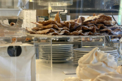 Le chiacchiere di carnevale. La storia delle chiacchiere di Carnevale è molto antica. Le origini risalgono, infatti, a quando nell'antica Roma si celebravano i Saturnali, una festa molto simile al Carnevale odierno. Durante questo periodo di banchetti e feste popolari, in cui tutti i canoni sociali venivano ribaltati, uno dei simboli d'eccesso erano le frictilia, dolci fritti nel grasso di maiale, distribuiti alla folla fra le strade della città. Apicio, uno dei più raffinati buongustai dei tempi antichi, descrive così la preparazione delle chiacchiere nel suo “De re coquinaria”: “Frittelle a base di uova e farina di farro tagliate a bocconcini, fritte nello strutto e poi tuffate nel miele”.